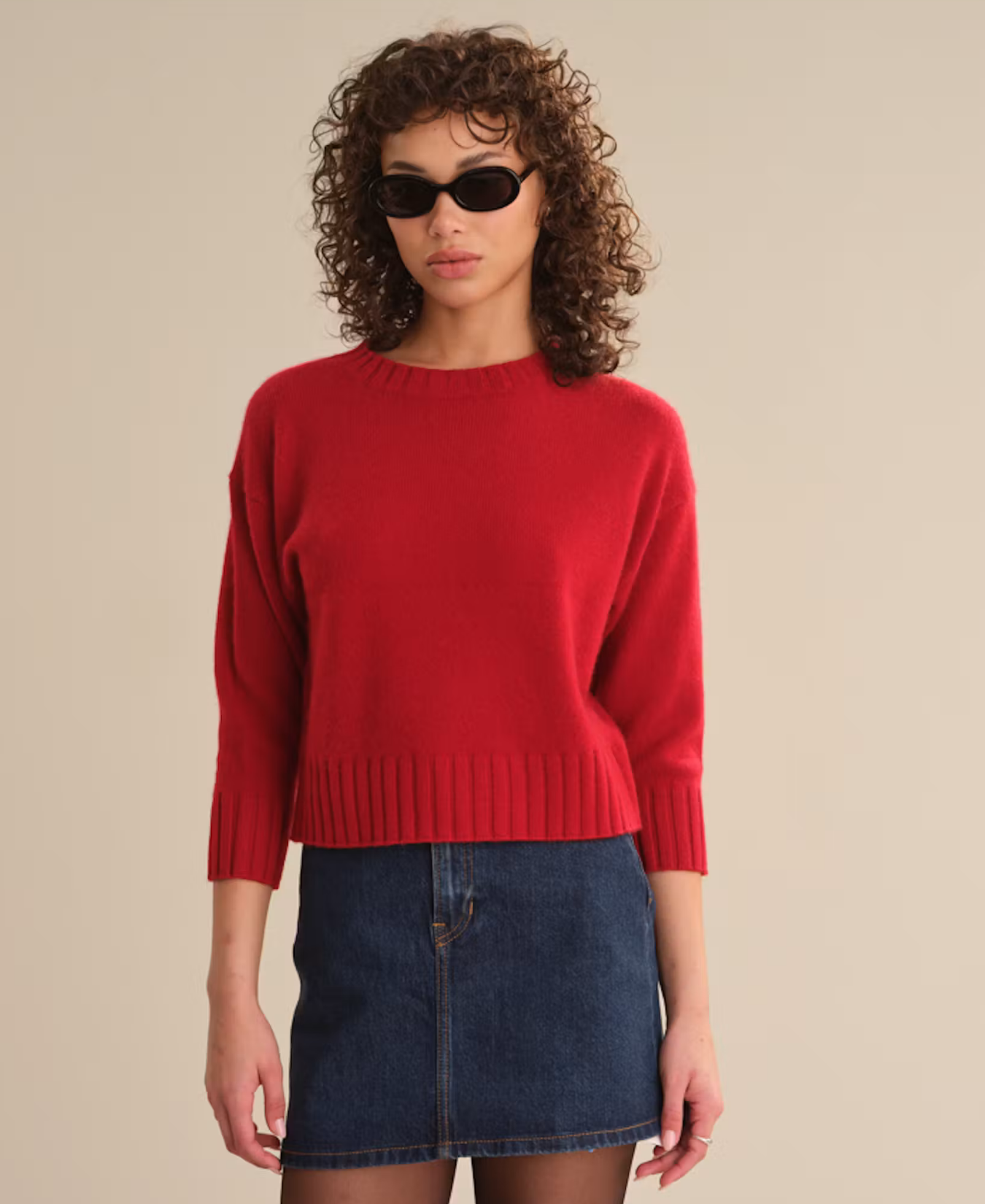 a woman wearing sunglasses and a red sweater