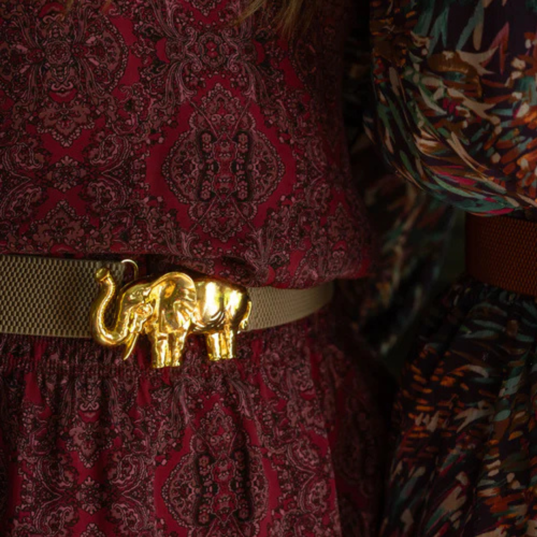 a woman wearing a belt with a gold elephant on it