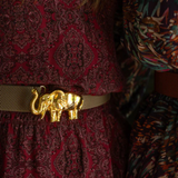 a woman wearing a belt with a gold elephant on it