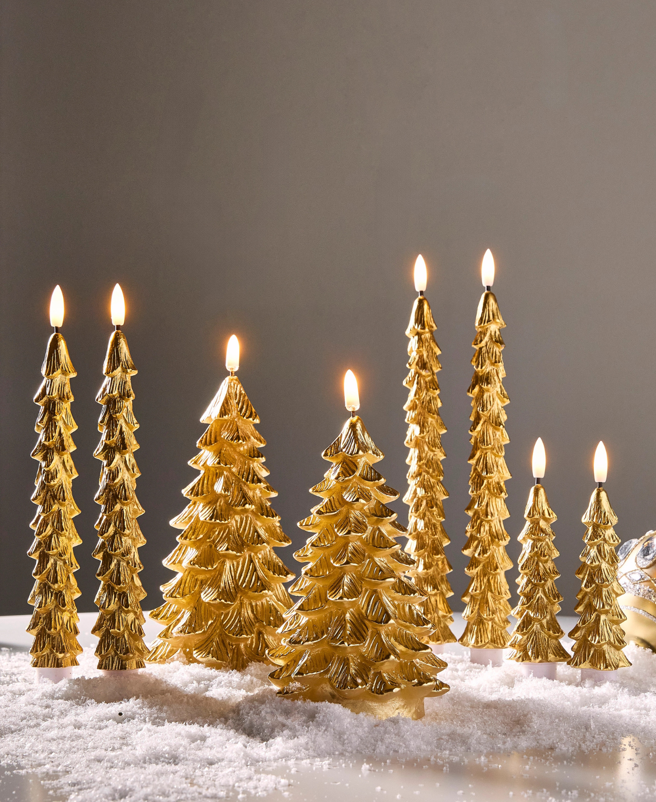 a group of gold trees with lit candles