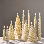 a group of white candles with trees on top
