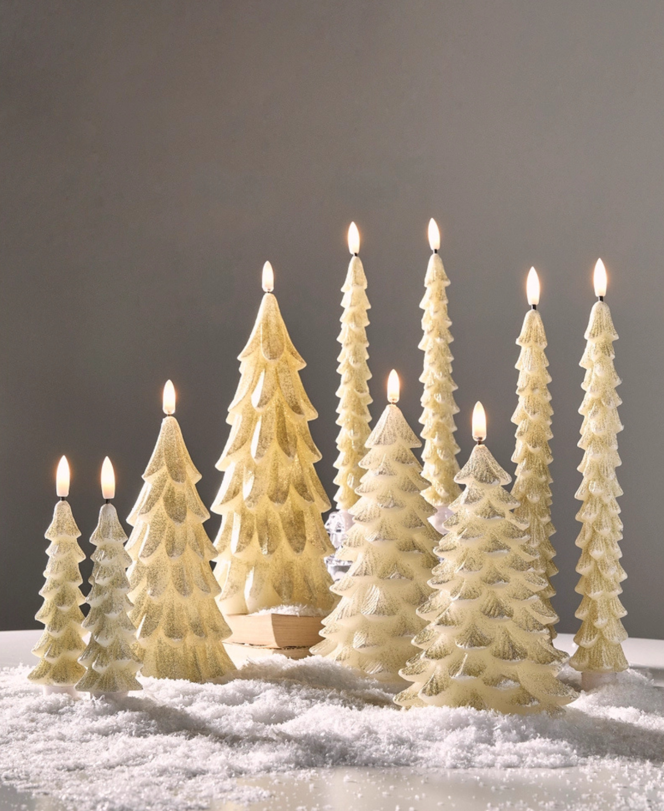 a group of white candles with trees on top