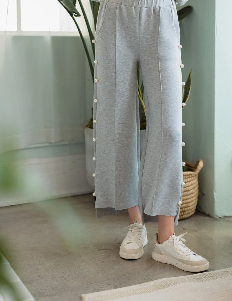 a person wearing grey pants and white shoes