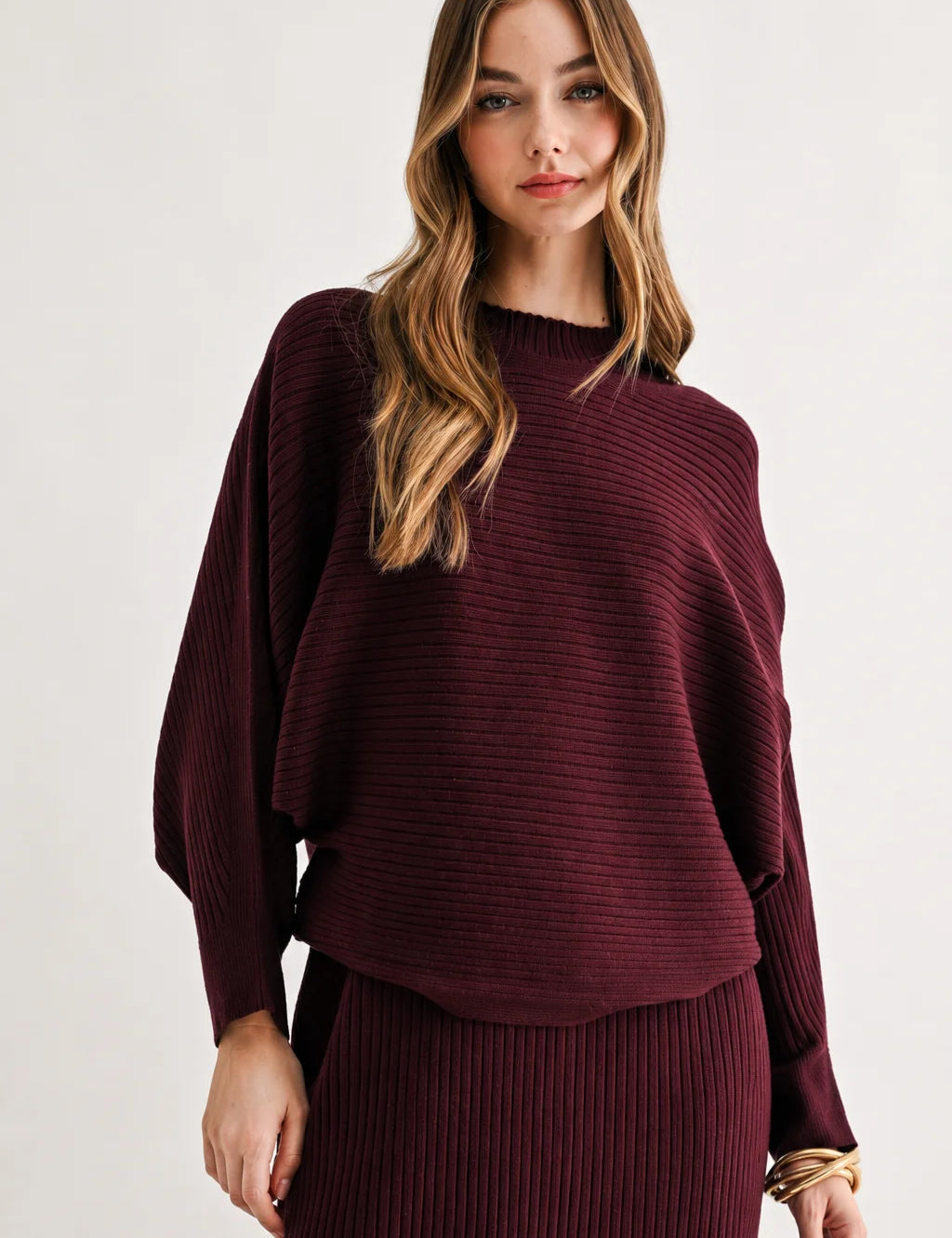 a woman in a maroon sweater and skirt