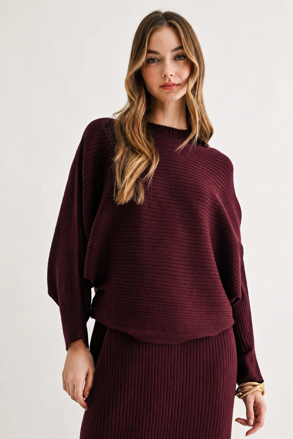 a woman in a maroon sweater and skirt