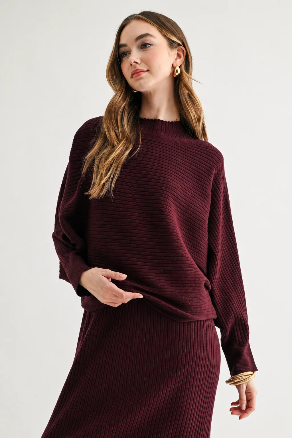 a woman in a maroon sweater and skirt