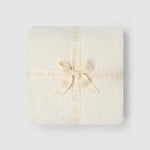 a white blanket wrapped in a ribbon