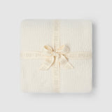 a white blanket wrapped in a ribbon