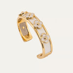 a gold and white bracelet with flowers
