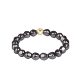 a black beaded bracelet with a gold bead