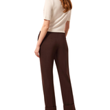 a woman in a white shirt and brown pants
