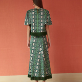 a woman in a green dress with Metropolitan Museum of Art in the background