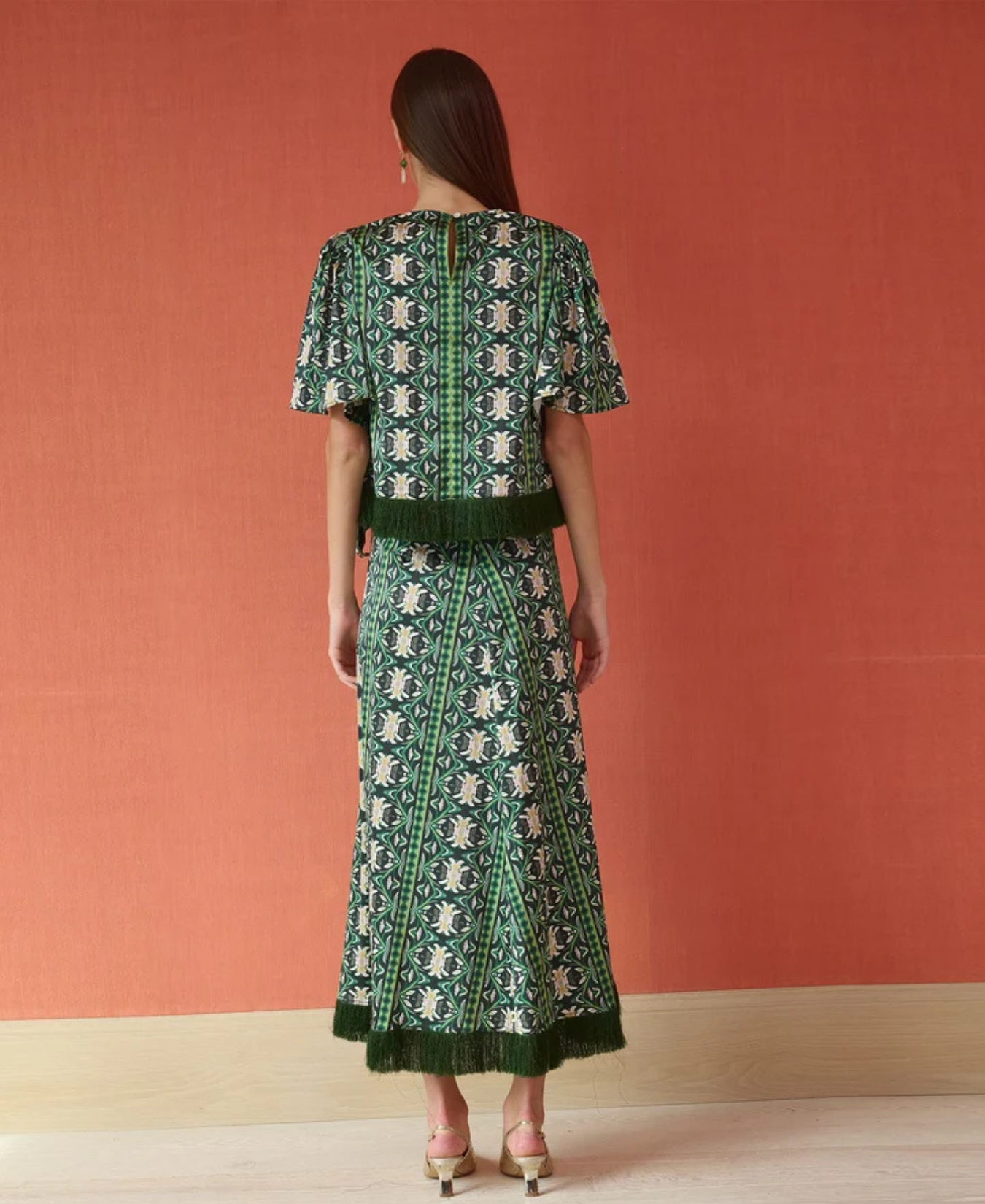 a woman in a green dress with Metropolitan Museum of Art in the background