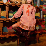 a woman in a red and white striped dress posing in front of a shelf