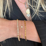 a woman wearing a black jacket and gold necklaces