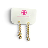 a white card with gold chain earrings