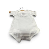 a white baby bodysuit on a swinger