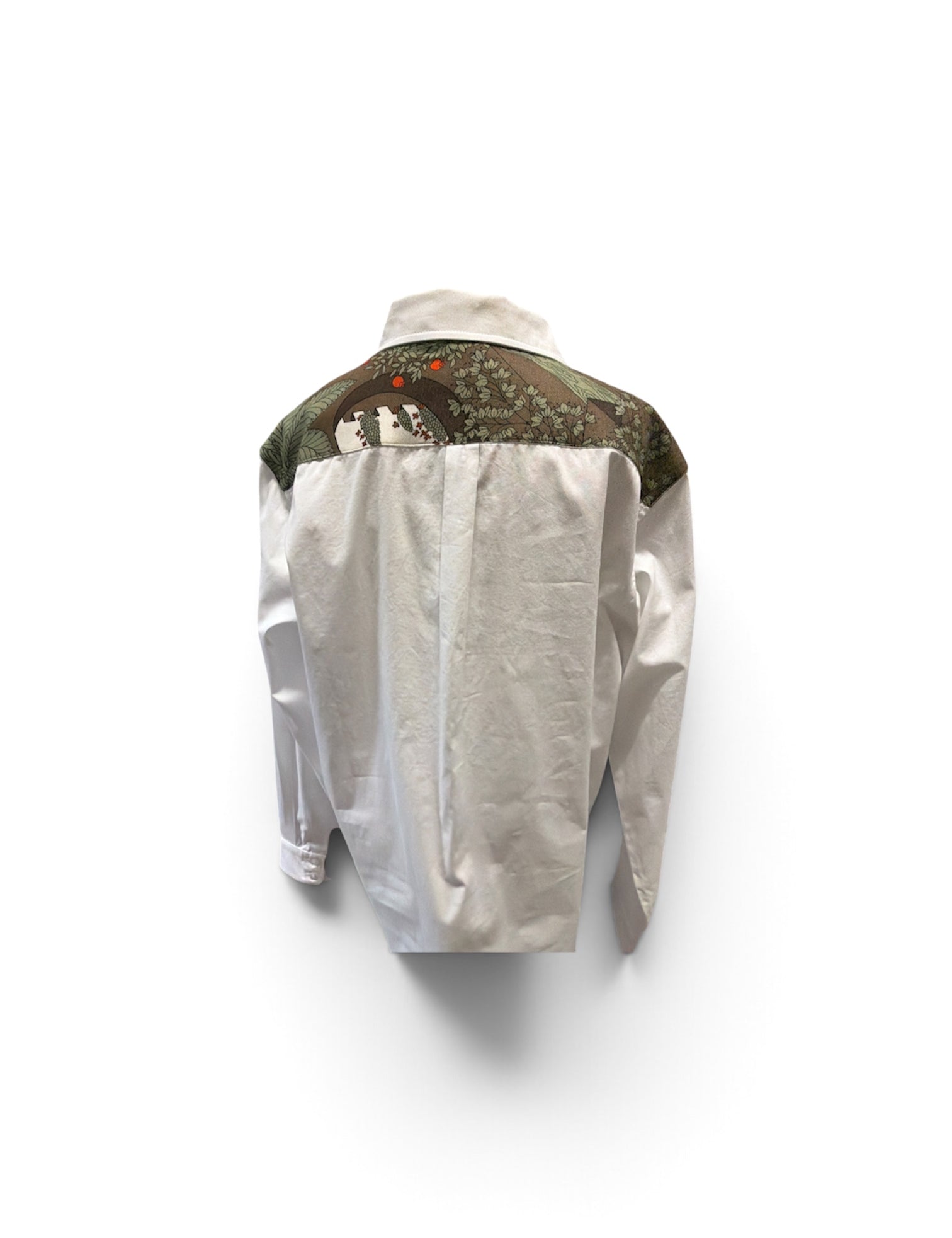 a white shirt with a green and brown design