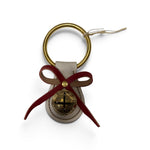 a key chain with a bell and a bow