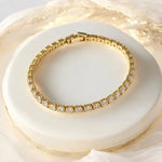 a gold bracelet on a white cake