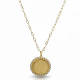 a gold necklace with a round pendant and a chain