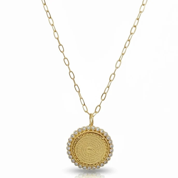 a gold necklace with a round pendant and a chain