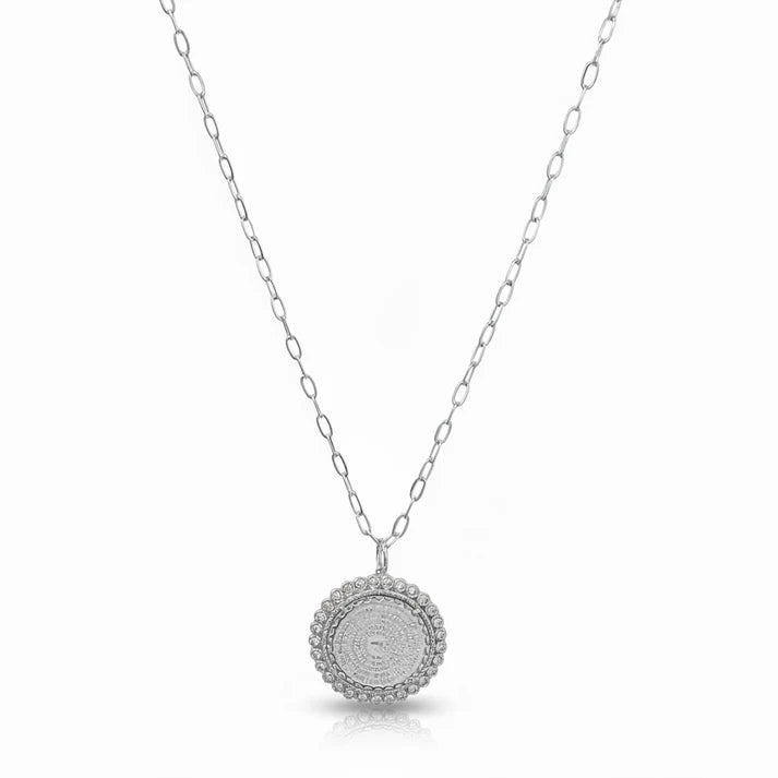 a silver necklace with a round pendant