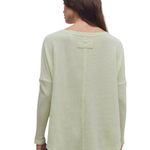 a woman wearing a green sweater