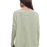 a woman wearing a green sweater