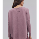 a woman wearing a pink sweater
