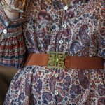 a woman wearing a dress and a belt
