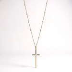 a gold cross necklace with a diamond