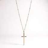 a gold cross necklace with a diamond