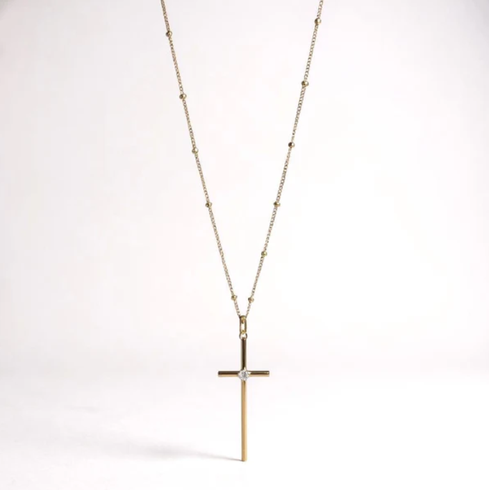 a gold cross necklace with a diamond