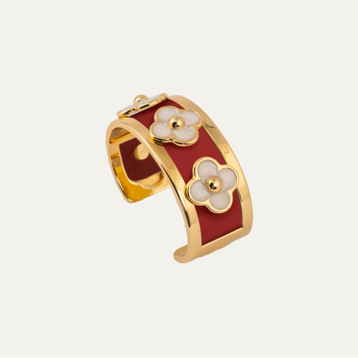 a gold and red bracelet with flowers