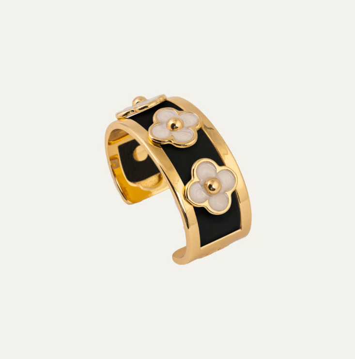 a gold and black bracelet with flowers