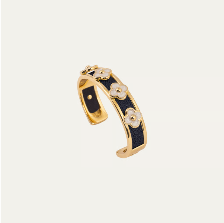 a gold and black bracelet with flowers
