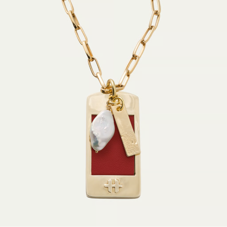 a gold chain with a red rectangular pendant and a pearl necklace