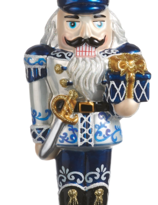 a nutcracker figurine with a sword and a gift