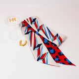 a red white and blue tie with a gold horseshoe and a clear container