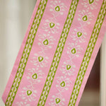 a pink and green fabric with white designs